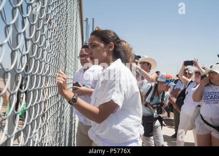 Tornillo, Texas, USA. 24 Juin, 2018. ALEXANDRIA OCASIO-CORTEZ, un candidat au congrès du New York 14, s'est secoué la clôture avec d'autres manifestants criant vers les agents d'immigration fédéraux pour leur demander de cesser la séparation des enfants et rendre les enfants logés dans les tentes près du Tornillo-Guadalupe Plaza sans frais. Des centaines de personnes se sont réunies à la Tornillo, TX, port d'entrée afin de protester contre l'administration d'Atout les politiques de tolérance zéro concernant l'immigration et la séparation des enfants de leurs parents lorsqu'ils sont arrêtés alors qu'ils entrent aux États-Unis. (Crédit Image : Banque D'Images