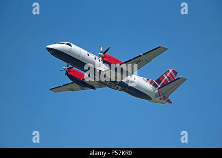 Loganair les Saab 340 dans son tartan écossais foie laissant l'aéroport d'Inverness pour son vol quotidien à travers à Stornoway dans les Hébrides extérieures. Banque D'Images