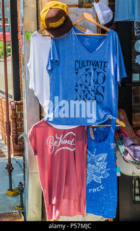 ASHEVILLE, NC, USA-24 JUIN 18 : une boutique spécialisée affiche Tee shirts, dire "Cultiver la bonté', 'Être Genre' et '... Free', et un capuchon publicité Banque D'Images