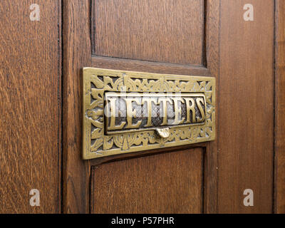 Décoratifs ornés de métal en laiton chambre letterbox avec le mot 'lettres' situé dans la porte en bois Banque D'Images