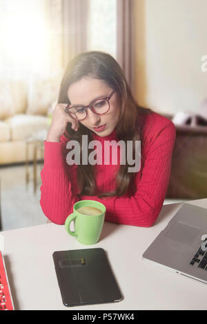 Tendu businesswoman at laptop with head in hands Banque D'Images