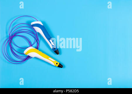 Stylos 3d avec des filaments de plastique en couleur sur fond bleu Banque D'Images