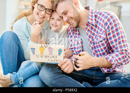 Portrait of happy aux teintes chaleureuses loving family posing sitting on floor in living room célébrer ensemble la fête des Pères Banque D'Images