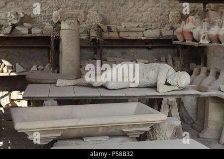 En fonte corps exposées parmi les amphores dans les Greniers du Forum (Francesi del Foro) dans le site archéologique de Pompéi (Pompei) près de Naples, Campanie, Italie. Des moulages de corps ont été construits à partir de plâtre dans les creux laissés par les organes désintégrés après l'éruption du Vésuve en 79 ap. Banque D'Images