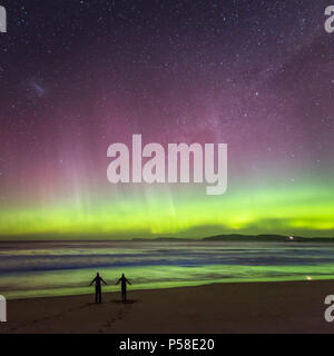 Couple dansant sur la plage sous l'Aurora Banque D'Images