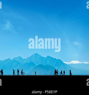 Les gens silhouette détente sur street sur ciel bleu et la haute montagne Banque D'Images