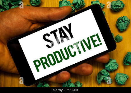 Texte de l'écriture de rester productifs Appel Motivation. L'efficacité de la productivité Concentration sens Concept Hand holding phone écran blanc written word Banque D'Images