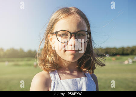 Girl looking at camera et souriant. Loisirs d'été. Girl à lunettes avec jante noir. Banque D'Images