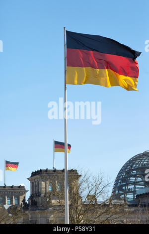 Berlin, Allemagne - Le drapeau national de l'Allemagne. Dans l'arrière-plan le Reichstag allemand avec d'autres drapeaux nationaux. Banque D'Images