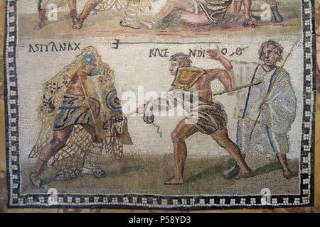 Gladiator lutte représentée dans la mosaïque romaine à partir du 3e siècle sur l'affichage dans le Musée Archéologique National (Museo Arqueológico Nacional) à Madrid, Espagne. Le secutor (lutte contre l'armée romaine gladiator) versus le retiarius (net romain chasse). Selon l'inscription latine, le secutor Astyanax et le retiarius Kalendio sont engagés dans un combat mortel. Le lanista (gladiator) formateur cheers-les. Le résultat est confirmé par les inscriptions : le mot VICIT apparaît à côté de astyanax, et à côté du nom Kalendio est un O barré d'une ligne, l'abréviation de Obiit ou la mort. Banque D'Images