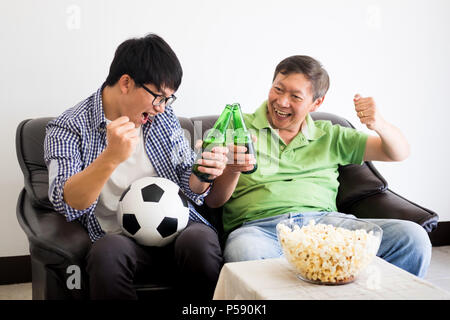 L'amitié, sports et divertissements - concept heureux amis clameurs et de regarder la télévision ensemble à la maison le soutien de l'équipe de football de la coupe du monde victoire. Banque D'Images