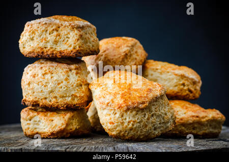 Petits pains au fromage traditionnel anglais scones sur table en bois sur fond sombre. Photo en gros plan Banque D'Images