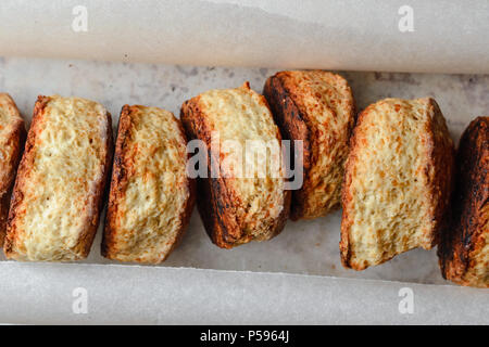 Petits pains au fromage anglais dans une rangée sur du parchemin pour la cuisson. Vue d'en haut Banque D'Images