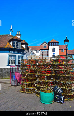 Une collection de homard sur le port de Lymington dans le Hampshire, avec la célèbre auberge de bateau en arrière-plan. Banque D'Images