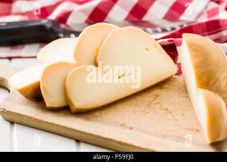 La Scamorza fromage fumé italien, sur une planche à découper. Banque D'Images