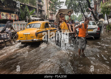 Kolkata. 26 Juin, 2018. Une part de l'extracteur de pousse-pousse transporte des passagers à travers la rue inondée après une forte pluie à Kolkata, en Inde le 26 juin 2018. Credit : Tumpa Mondal/Xinhua/Alamy Live News Banque D'Images