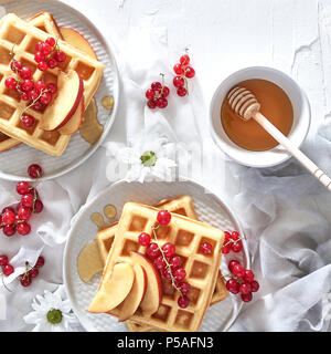 Mise à plat des gaufres belges traditionnels avec des fruits et du miel sur fond blanc. Le petit-déjeuner. Vue d'en haut, carré culture. Banque D'Images