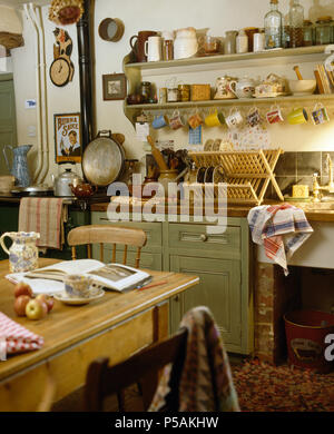Table et chaises en bois dans la cuisine à l'ancienne unité vert pastel avec à côté d'Aga Banque D'Images