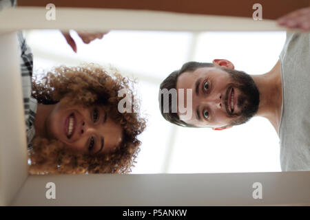 Vue de dessous un jeune couple à l'intérieur de la boîte. Banque D'Images