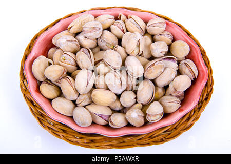 Les pistaches dans un bol isolated on white Banque D'Images