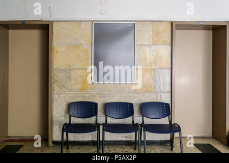 Tableau noir sur un vieux mur de l'hôpital entouré par des portes d'une des chaises Banque D'Images