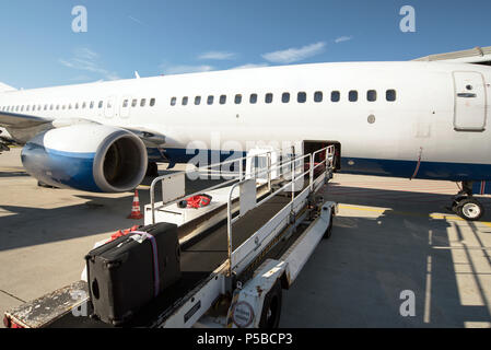 Le personnel au sol de la manipulation d'un avion avant le départ à l'aéroport - charger des bagages Banque D'Images