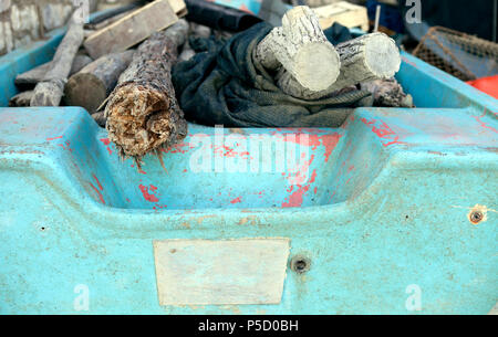 Ein mit Holzstöcken und Tüchern belaenes, hellblaues Boot am Strand von Ancona, Italien. Banque D'Images