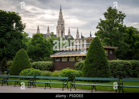 Des bancs, des toilettes publiques, arbres et haies de Volksgarten à Vienne (Autriche) avec l'Hôtel de Ville en Backgounrd Banque D'Images