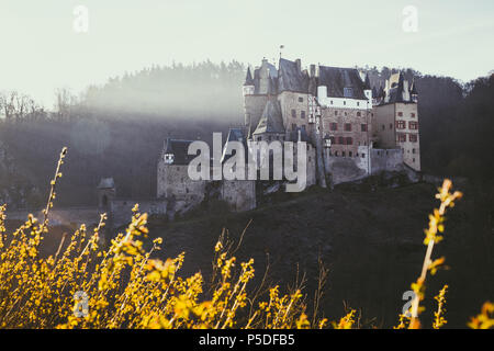 Belle vue sur Château Eltz célèbre dans la ville pittoresque de golden lumière du matin au lever du soleil à l'automne avec retro vintage style VSCO Wierschem, effet de filtre, Allemagne Banque D'Images