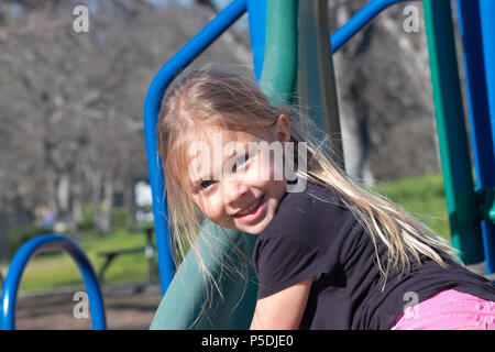 Jeune fille blonde jouant dans le parc Banque D'Images