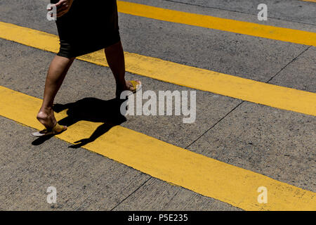 Femme traverser la route dans le centre de Hong Kong Banque D'Images