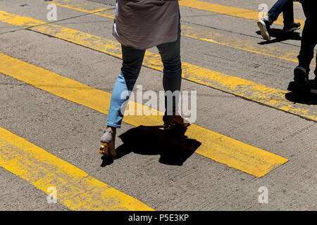 Walking Woman crossing road à Causeway Bay shopping district à Hong Kong Banque D'Images