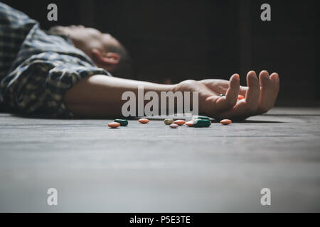 L'homme se suicide par une surdose de médicaments. Close up de surdosage comprimés et l'addict. Banque D'Images