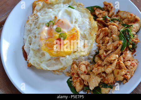 Poulet frit épicé avec des feuilles de basilic sur le riz topping œuf frit Banque D'Images