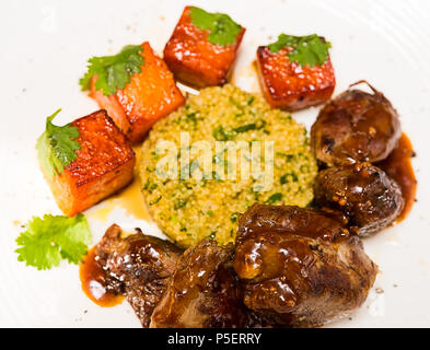 La viande biologique d'agneau cuit avec des tranches de citrouille et le quinoa dans un style oriental Banque D'Images