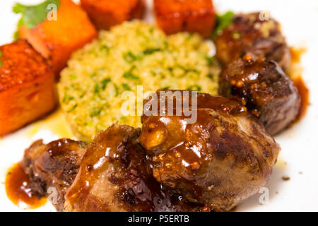 La viande biologique d'agneau cuit avec des tranches de citrouille et le quinoa dans un style oriental Banque D'Images