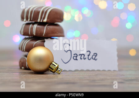 Une pile de biscuits au chocolat et d'un brouhaha d'or avec une note pour Santa Banque D'Images