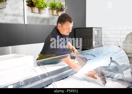 Vendeur mâle truite à mettre au réfrigérateur fish shop Banque D'Images