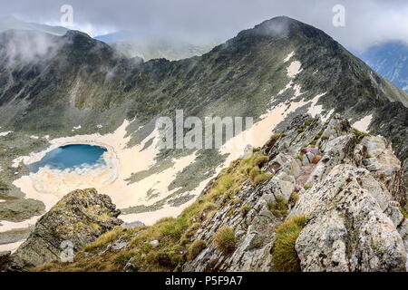 Incroyable, ciel voilé vue du sommet Musala sur lac gelé et couvert de montagnes de Rila brouillard Banque D'Images
