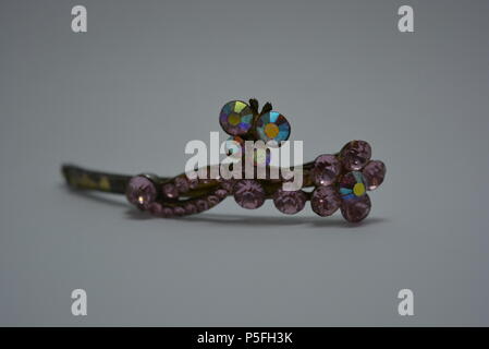 Beaux bijoux pour femmes et bijoux de fantaisie élégants. Pince à cheveux élégante en métal pour femmes avec de grandes pierres roses placées sur fond blanc. Banque D'Images