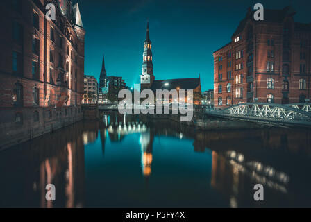 La vue classique du célèbre quartier des entrepôts de Speicherstadt avec église St Katharinen allumé dans le magnifique coucher de soleil au crépuscule après twilight, Hambourg, Allemagne Banque D'Images