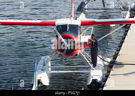 Crewman ravitaille un vintage de Harbour Air Seaplanes de Havilland Canada DHC-2 Beaver Hydravion au port de Vancouver Flight Centre, BC, Canada. Banque D'Images