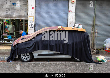 Préparer les résidents à la tempête en couvrant leurs voitures à l'aide de couvertures ou de matériaux de protection s'attendent à ce que le tonnerre, forte grêle forte à Istanbul, Turquie. Banque D'Images