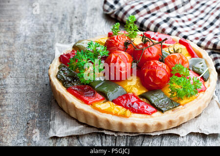 Quiche végétarienne colorée avec le poivre et les tomates cerise sur table en bois Banque D'Images