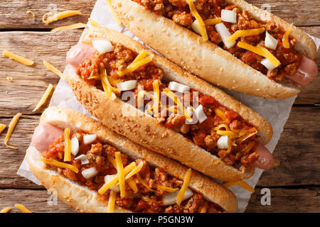 Chilli hot dog avec du fromage cheddar et sauce épicée sur table. haut horizontale Vue de dessus Banque D'Images