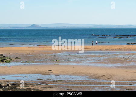 Firth of Forth - couple sur la plage de Anstruther, Fife, à la recherche sur le Firth of Forth à North Berwick et des grandes lignes de North Berwick Law Banque D'Images