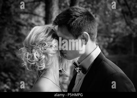 Le marié embrasse la mariée et l'embrasse doucement. Marche de mariage Banque D'Images