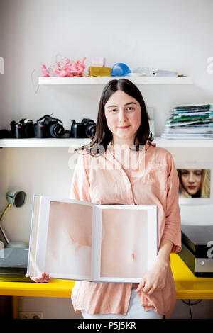 Berlin, Allemagne. 26 Juin, 2018. Le photographe artistique Eylul Aslan tenant son livre 'Trompe l·oeil' en face de son bureau dans son appartement à Berlin-Neukoelln. Credit : Christoph Soeder/dpa/Alamy Live News Banque D'Images