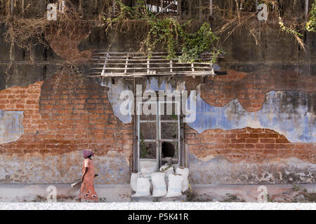 Socs femme dans la cour d'un vieux bâtiment colonial utilisé pour le commerce dans le gingembre. Bazar Road, Kochi, Kerala, Inde. Banque D'Images