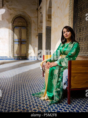 Fes, MAROC - CIRCA AVRIL 2017 : Jeune femme marocaine habillés en vêtements traditionnels posant devant une fenêtre dans le El Glaoui Palace Banque D'Images